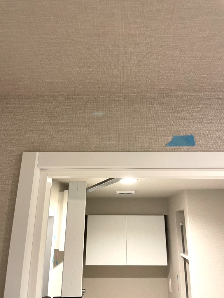 施工後：ドア上枠の傷が補修されクロスも整えられた状態