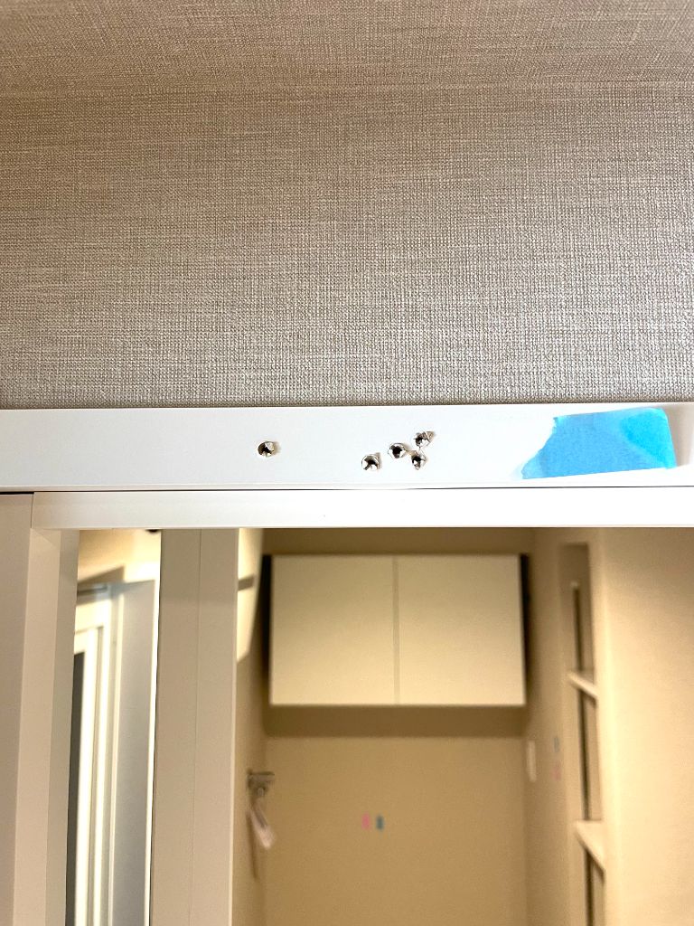 施工前：ドア上枠にビス穴・欠け・めくれが複数発生している状態